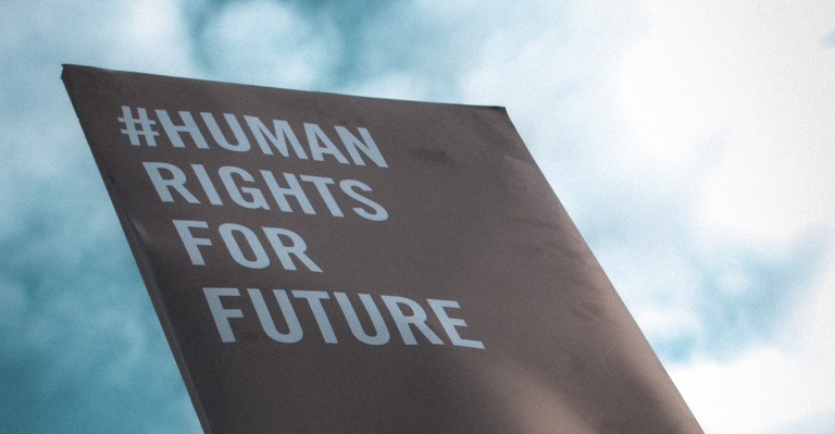 Ein Plakat mit dem Text #Human rights for future vor einem blauen Himmel