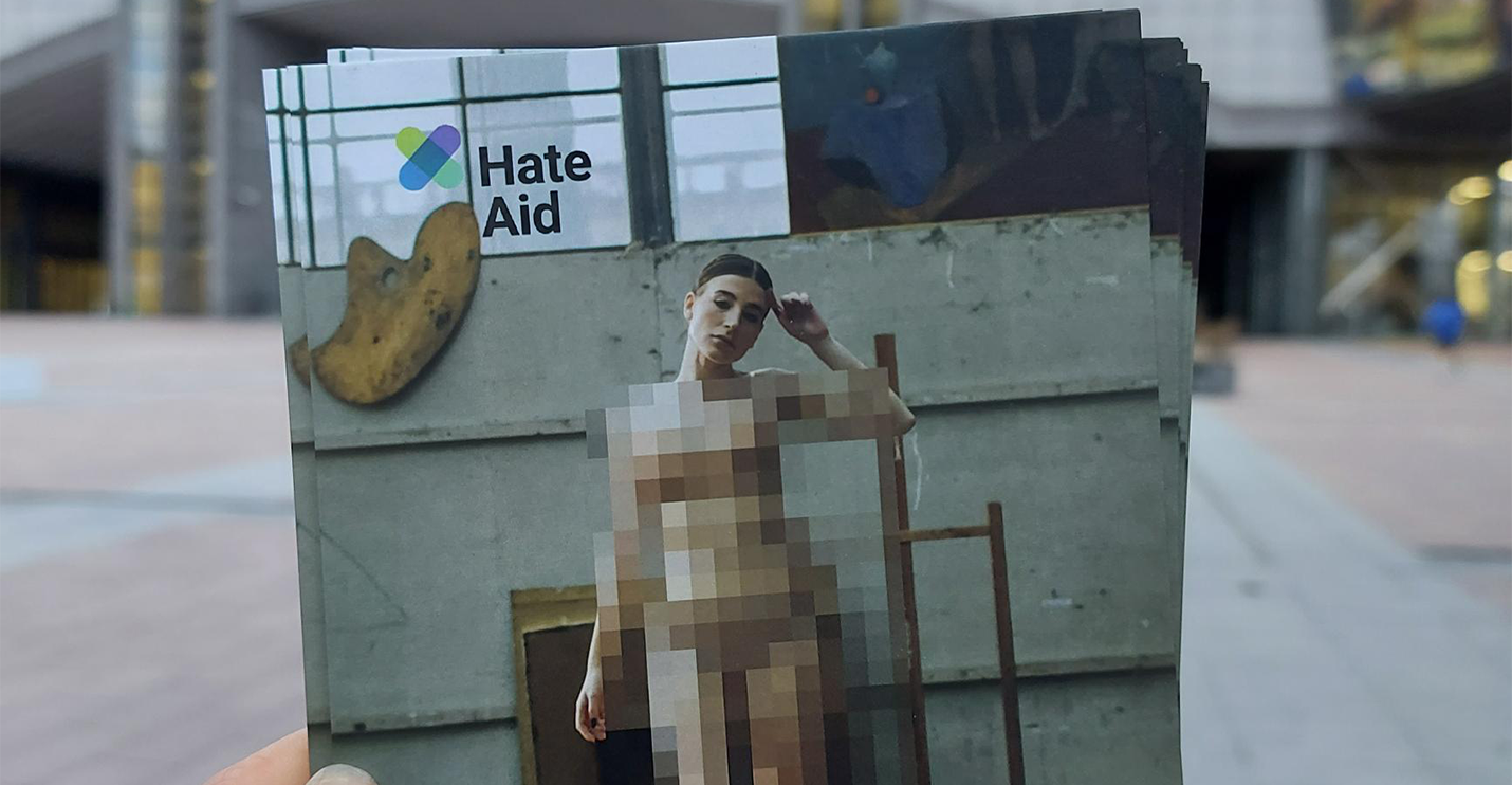 A postcard against image-based sexual abuse in front of the European Parliament, it shows a censored naked woman.