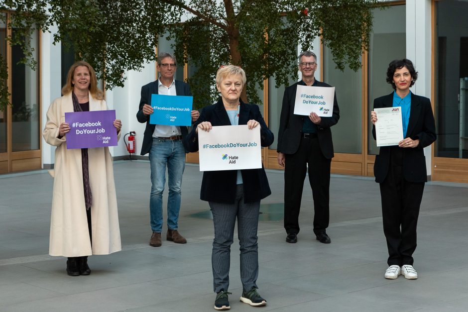 Renate Künast, Anna-Lena von Hodenberg und andere halten Schilder im Rahmen des Grundsatzprozesses gegen Facebook in den Händen.