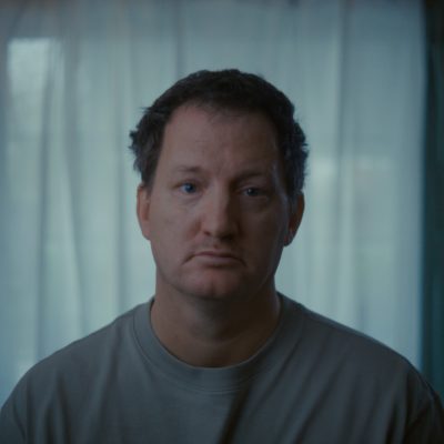 Porträtfoto von einem Mann in einem grauen T-Shirt.