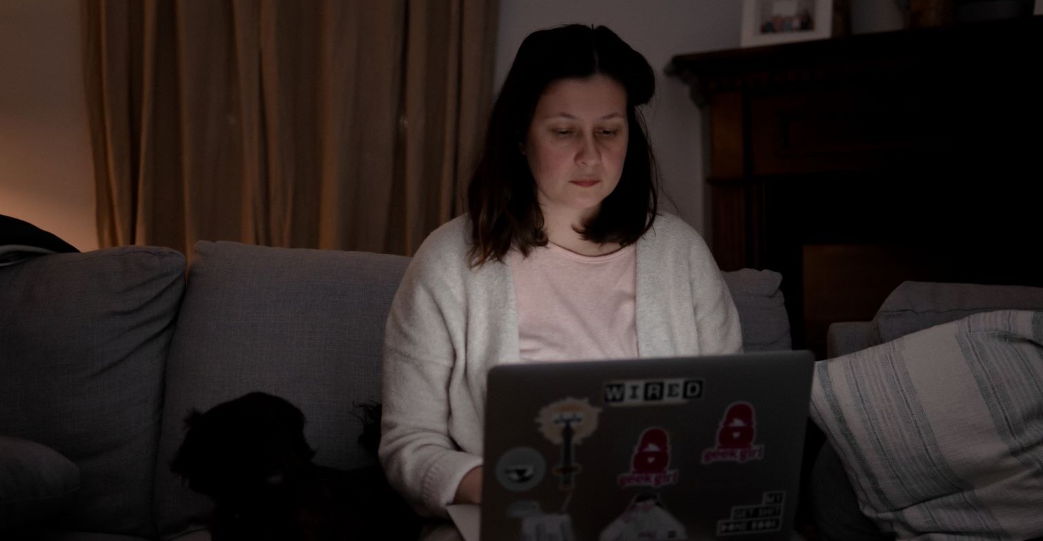 Person sitzt im dunkeln am Laptop.