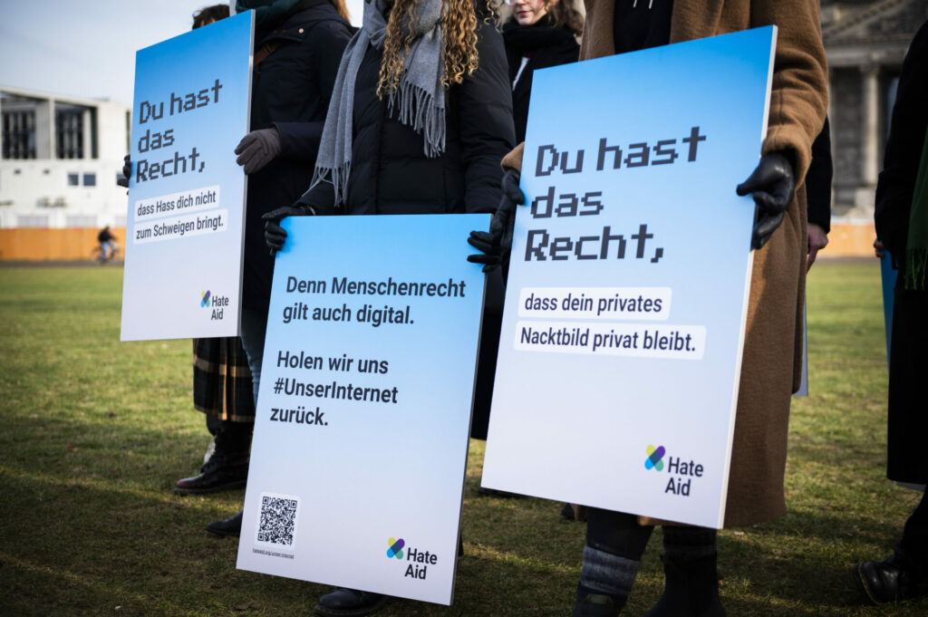 HateAid Menschenrechtskampagne #UnserInternet. Auftakt vor dem Bundestag. Zu sehen sind im Detail drei Plakate mit den Aufschriften "Du hast das Recht, dass Hass dich nicht zum Schweigen bringt.", "Denn Menschenrecht gilt auch digital." sowie "Du hast das Recht, dass dein privates Nacktbild privat bleibt". Copyright: HateAid