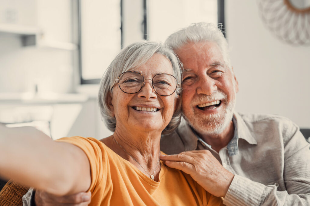 Zwei ältere Menschen machen lachend ein Selfie