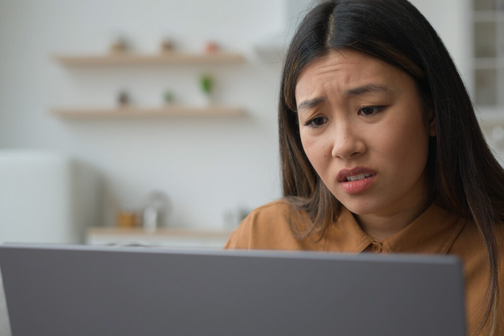 Person sitzt traurig vor dem Laptop.