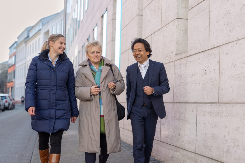 Gruppenfoto von Josephine Ballon, Renate Künast und Chan-jo Jun (von links nach rechts) auf dem Web zum Bundesgerichtshof in Karlsruhe. In der Mitte: Renate Künast, Bundestagsabgeordnete und HateAid-Klientin.