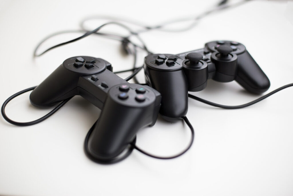 bmj-hass-auf-gaming-plattformen-artikel-c-shutterstock-vladyslav-horoshevych(1) Zwei schwarze Gaming-Controller auf weißem Tisch