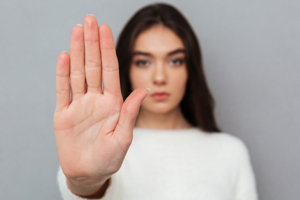 Zu sehen ist eine Frau, die mit ihrer rechten Hand Richtung Kamera ein Stopp-Signal signalisiert.
Copyright: Magnific